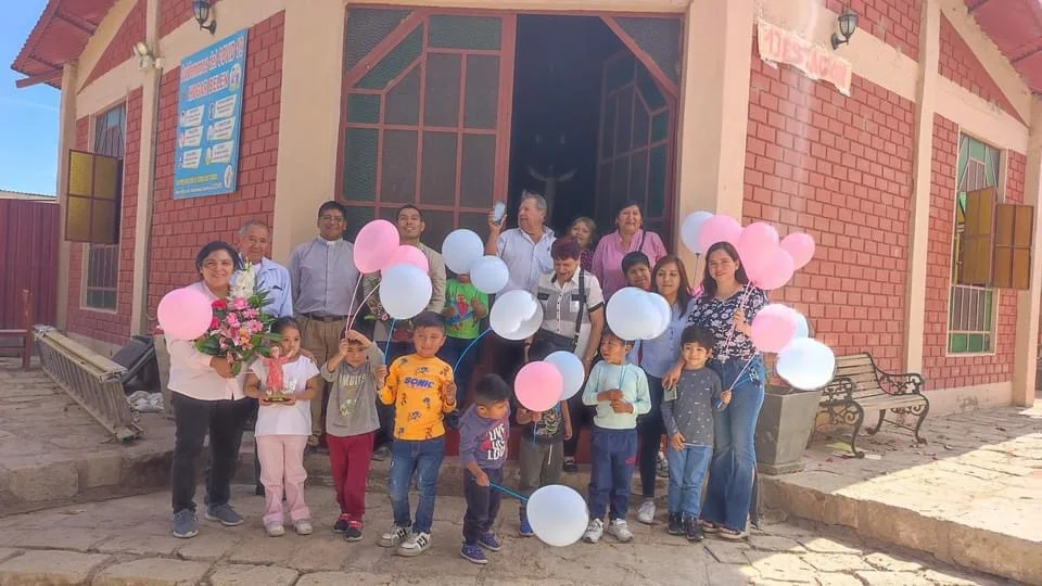 Children and volunteers gathered outside a building in Peru