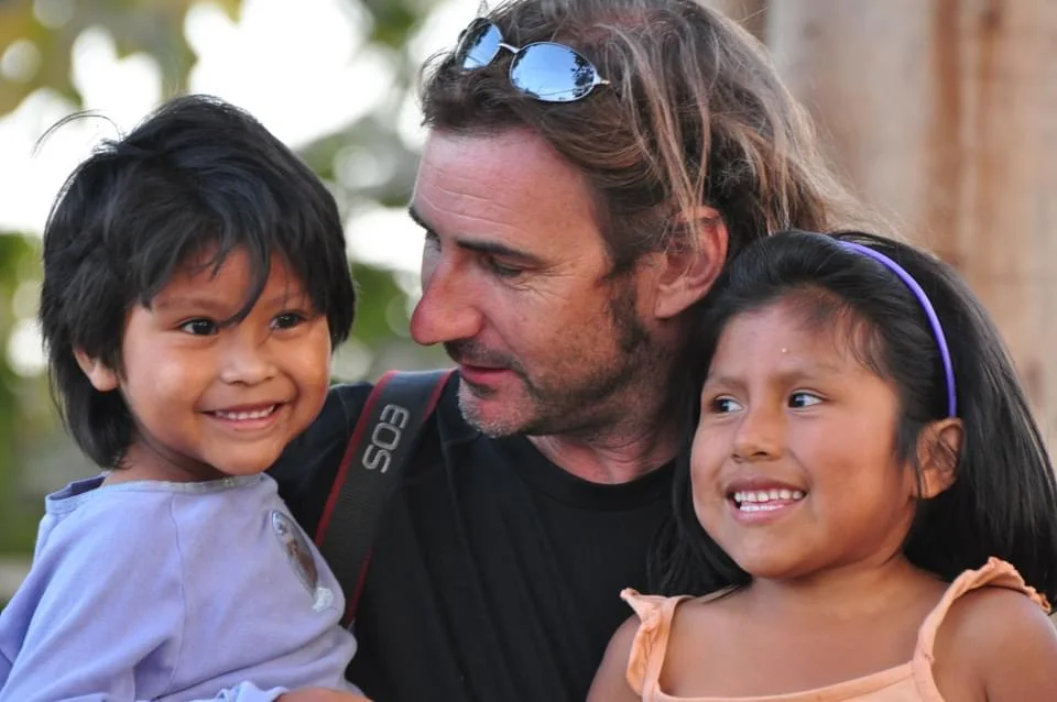 A volunteer with two children during DO GOOD work in Peru