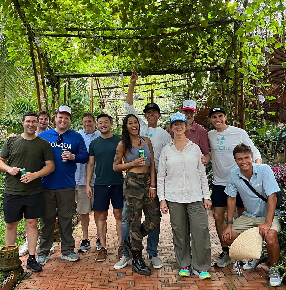 A community team gathered outdoors among trees